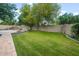 Lush backyard with a green lawn, mature trees, and a cozy seating area at 8219 S Pecan Grove Cir, Tempe, AZ 85284