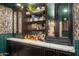 Chic bar area featuring sleek cabinetry, marble countertops, and display shelving at 8219 S Pecan Grove Cir, Tempe, AZ 85284