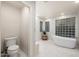 Bright bathroom featuring a freestanding tub, glass block windows and mosaic tile flooring at 8219 S Pecan Grove Cir, Tempe, AZ 85284