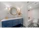 Stylish bathroom features a navy vanity, gold accents, and a round mirror at 8219 S Pecan Grove Cir, Tempe, AZ 85284