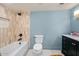 Bright bathroom featuring a tub, toilet, and vanity, all complemented by neutral and blue tones at 8219 S Pecan Grove Cir, Tempe, AZ 85284