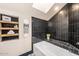 Modern bathroom with black tiles, skylight, and built-in shelving at 8219 S Pecan Grove Cir, Tempe, AZ 85284