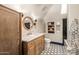 Charming bathroom with wood vanity, round mirror, and patterned floor tiles at 8219 S Pecan Grove Cir, Tempe, AZ 85284