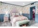 Cozy bedroom with playful wallpaper, soft pink bedding, and a comfortable green bench at 8219 S Pecan Grove Cir, Tempe, AZ 85284