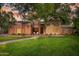 Charming home featuring lush landscaping, manicured lawn, brick accents, and inviting outdoor seating at the front door at 8219 S Pecan Grove Cir, Tempe, AZ 85284