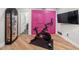 Bright home gym showcasing hardwood floors, Peloton bike, and a colorful accent wall at 8219 S Pecan Grove Cir, Tempe, AZ 85284