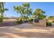 A backyard area with a built-in BBQ area, mature trees, and lush green bushes at 8402 W Rosemonte Dr, Peoria, AZ 85382