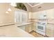 Well-lit kitchen featuring tiled countertops, white cabinets, and a breakfast bar area at 8402 W Rosemonte Dr, Peoria, AZ 85382