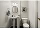 Well-lit powder room featuring pedestal sink, tile floors, and elegant fixtures at 9039 N Concho Ln, Phoenix, AZ 85028
