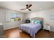 Relaxing bedroom featuring a ceiling fan, neutral paint, and large window at 9039 N Concho Ln, Phoenix, AZ 85028