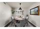 Cozy dining room with a round table, gray chairs, and a modern pendant light fixture at 9039 N Concho Ln, Phoenix, AZ 85028