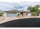 Charming single-story home with a stone accent wall, desert landscaping, and an attached two-car garage at 9039 N Concho Ln, Phoenix, AZ 85028