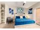 Bright bedroom with a queen bed, carpeted floors, and an art collection on the walls at 10030 W Indian School Rd # 215, Phoenix, AZ 85037