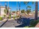 Gated entrance with lush landscaping and palm trees ensures privacy and security at 10030 W Indian School Rd # 215, Phoenix, AZ 85037