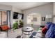Inviting living room with modern decor, a flat-screen TV, and sliding glass doors at 10030 W Indian School Rd # 215, Phoenix, AZ 85037