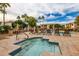 Hot tub on a sunny day next to a pool area with lounge seating and shady palms at 10030 W Indian School Rd # 215, Phoenix, AZ 85037