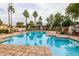 A serene community pool offers residents a refreshing escape with lounge seating, palms, and grassy areas at 10030 W Indian School Rd # 215, Phoenix, AZ 85037