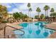 Relaxing pool with lounge chairs and many palm trees offering shade in the community at 10030 W Indian School Rd # 215, Phoenix, AZ 85037