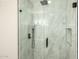 Modern shower featuring white marble tile, sleek black hardware, and a rainfall showerhead at 10030 W Indian School Rd # 215, Phoenix, AZ 85037