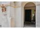 Close-up of the front door featuring an arched entrance, exterior sconce, and clear house numbers at 11158 N 162Nd Dr, Surprise, AZ 85379