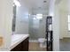 Well-lit bathroom featuring a glass enclosed shower, white toilet, and neutral earth tone tile at 120 W Milada Dr, Phoenix, AZ 85041