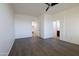 Open bedroom with hard wood floors, ceiling fan, and adjacent bathroom and laundry room at 120 W Milada Dr, Phoenix, AZ 85041