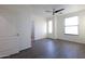 A spacious bedroom with dark vinyl floors, a ceiling fan, and bright windows at 120 W Milada Dr, Phoenix, AZ 85041