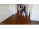 A hallway shows dark wood floors, white walls, and a glimpse into the kitchen and bathroom at 120 W Milada Dr, Phoenix, AZ 85041
