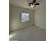Bright bedroom featuring wood-look tile flooring, a ceiling fan, and a window overlooking the fenced backyard at 14860 S Capistrano Rd, Arizona City, AZ 85123