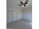 A spacious bedroom with tile floors, ceiling fan with lights, and closet at 14860 S Capistrano Rd, Arizona City, AZ 85123