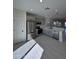 Open-concept kitchen with stainless steel appliances, light gray cabinets, and quartz countertops at 14860 S Capistrano Rd, Arizona City, AZ 85123