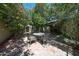Inviting outdoor patio shaded by fruit trees and pink bougainvillea with a table and chairs at 1500 N Markdale -- # 68, Mesa, AZ 85201
