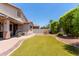 Private backyard offers artificial turf, a covered patio, landscaping, and desert surroundings at 157 W Leatherwood Ave, San Tan Valley, AZ 85140