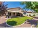 Landscaped backyard offers artificial turf, desert rock, and a covered patio perfect for entertaining at 157 W Leatherwood Ave, San Tan Valley, AZ 85140