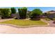 Private backyard with artificial grass, mature trees, and a paved patio area at 157 W Leatherwood Ave, San Tan Valley, AZ 85140