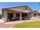 Backyard features artificial turf, a covered patio, desert landscaping, and a barbecue grill at 157 W Leatherwood Ave, San Tan Valley, AZ 85140