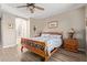 Relaxing bedroom features a wood-framed bed, ceiling fan, and en suite bathroom at 157 W Leatherwood Ave, San Tan Valley, AZ 85140