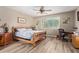 Comfortable bedroom features a wood-framed bed, ceiling fan, and ample natural light at 157 W Leatherwood Ave, San Tan Valley, AZ 85140