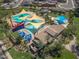 Aerial view of a community pool with lounge areas, splash pad, and shade structures at 157 W Leatherwood Ave, San Tan Valley, AZ 85140