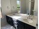 Bathroom with dual sinks, dark cabinets, and a large mirror at 15801 W Meade Ln, Goodyear, AZ 85338