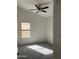Bright bedroom featuring a ceiling fan, a window, and neutral carpet flooring at 15801 W Meade Ln, Goodyear, AZ 85338