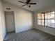 Cozy bedroom featuring gray carpet, a window, and ceiling fan at 15801 W Meade Ln, Goodyear, AZ 85338