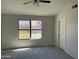 Bright bedroom with gray carpet, and a window overlooking the backyard at 15801 W Meade Ln, Goodyear, AZ 85338