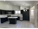 Modern kitchen featuring black cabinets, stainless steel appliances, an island and tile flooring at 15801 W Meade Ln, Goodyear, AZ 85338