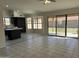Open-concept living space with tile floors, large windows, and sliding glass doors to backyard at 15801 W Meade Ln, Goodyear, AZ 85338