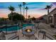 Beautiful backyard at sunset with a sparkling pool, fire pit, palm trees, and comfortable seating at 16608 S 16Th Ave, Phoenix, AZ 85045