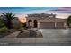 Inviting two-story home with a three-car garage, desert landscaping, and beautiful sunset skies at 16608 S 16Th Ave, Phoenix, AZ 85045