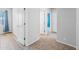Hallway with neutral carpet and paint, with multiple doors leading to other rooms at 16608 S 16Th Ave, Phoenix, AZ 85045