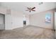 Spacious main bedroom with soft carpet, a ceiling fan, and natural light streaming through the large window at 16608 S 16Th Ave, Phoenix, AZ 85045