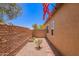 Narrow backyard featuring a stone path, block fence, and desert landscaping at 1702 W Amberwood Dr, Phoenix, AZ 85045